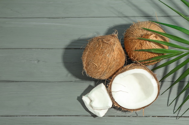 Noci di cocco con ramo di palma sul tavolo di legno