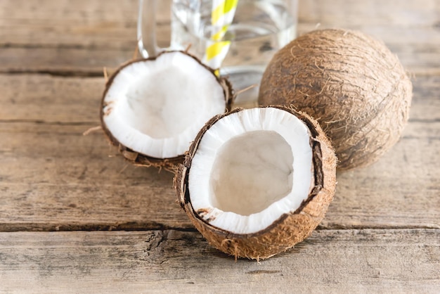 Noci di cocco e barattolo di vetro con acqua di cocco Vecchio sfondo di legno Straw Copy Space