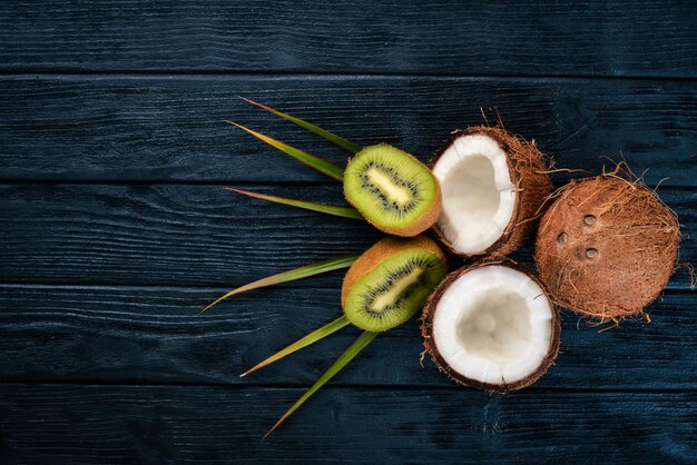 Noci di cocco e kiwi su uno sfondo di legno Frutta e noci tropicali Vista dall'alto Spazio libero per il testo