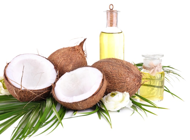 Noci di cocco e olio di cocco isolati su bianco