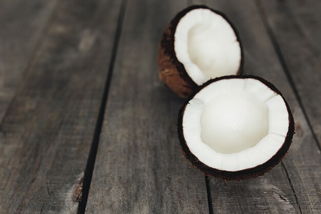 Noci di cocco rotte su fondo di legno grigio. Polpa di cocco bianca. Foto di alta qualità