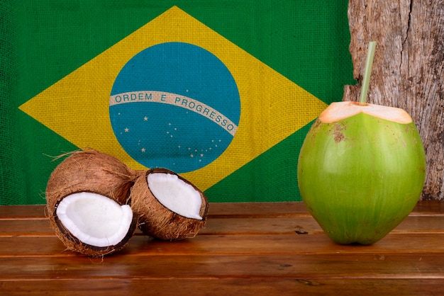 Noci di cocco verdi e marroni con bandiera brasiliana