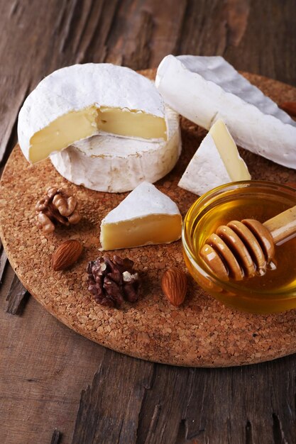 Noci di formaggio Camembert miele e pane sul tagliere su fondo di legno