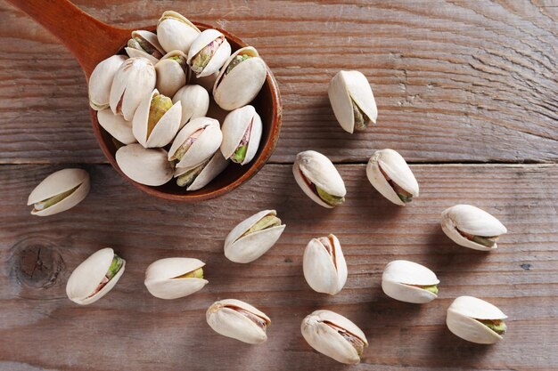 Noci di pistacchio in un cucchiaio su una superficie di legno vista dall'alto