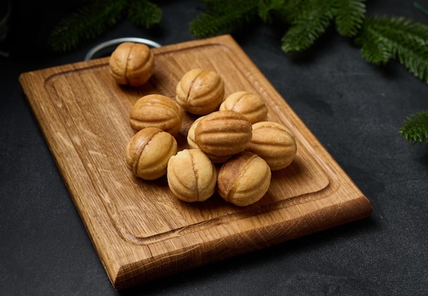 Noci dolci al forno con latte condensato su una tavola di legno, vista dall'alto