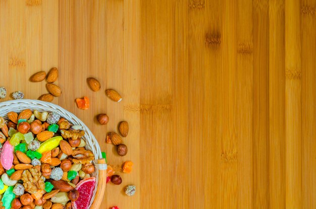 Noci e frutta candita su un fondo di legno con un posto da copiare.