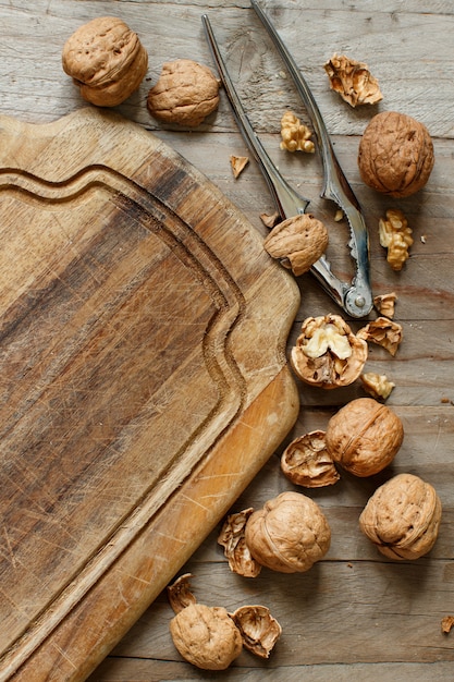 Noci fresche con uno schiaccianoci su un vecchio tavolo di legno