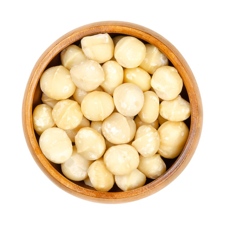 Noci macadamia sgusciate crude in una ciotola di legno