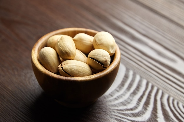 Noci pecan in ciotola sul tavolo di legno marrone