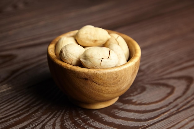 Noci pecan in ciotola sul tavolo di legno marrone