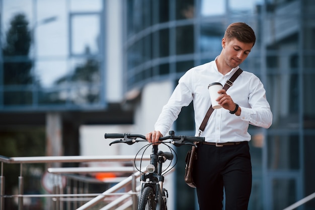 Non farò tardi. L'uomo d'affari in abiti formali con la bicicletta nera è in città.