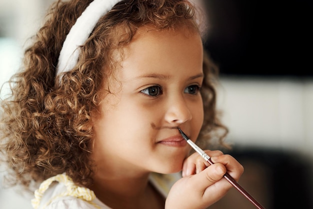 Non lo laverò via. Inquadratura di una bambina che si dipinge la faccia per sembrare un coniglietto