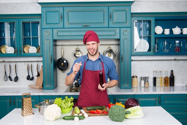 Non mi piace l'odore. giovane chef cuoco in cucina. importante fonte di nutrienti. prodotto dimagrante. aggiungi alla tua dieta. benefici per la salute del cibo biologico. l'uomo apre l'aceto di vino. ingrediente segreto.