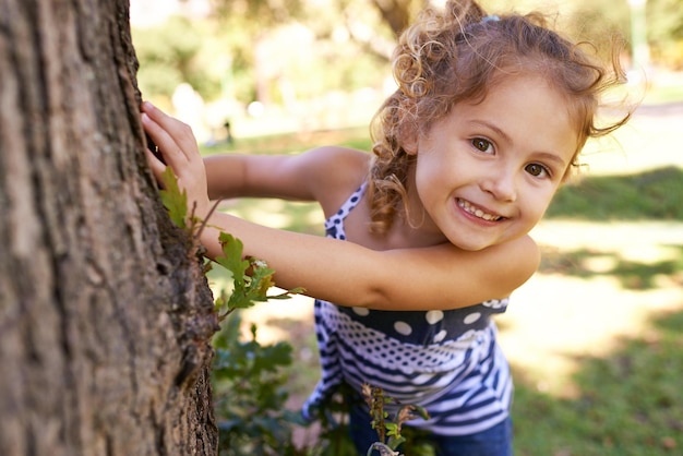 Non mi troveranno qui Ritratto di una bambina nascosta dietro un albero in un parco