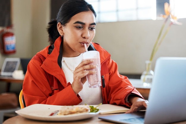 Non posso permettermi di fare una vera pausa pranzo Foto di una giovane studentessa che usa un laptop mentre studiava al college