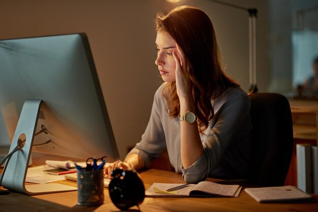 Non può farlo molto più a lungo Inquadratura di una giovane donna d'affari attraente che sembra stressata mentre lavora fino a tardi in ufficio