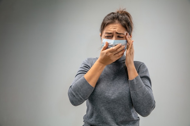 Non riesco a respirare. La donna caucasica che indossa la maschera di protezione delle vie respiratorie contro l'inquinamento atmosferico e le particelle di polvere supera i limiti di sicurezza. Sanità, ambiente, concetto di ecologia. Allergia, mal di testa.