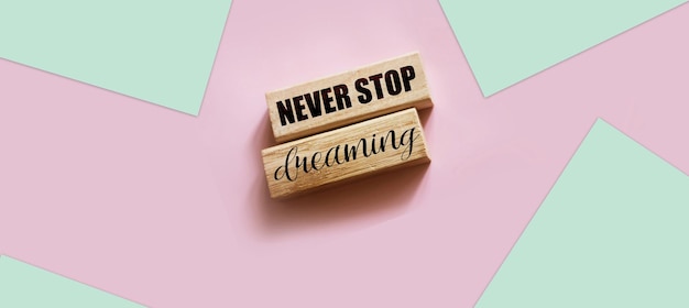 Non smettere mai di sognare parole stampate su blocchi di legno Concetto di mentalità positiva