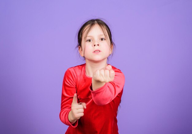 Non toccarmi nemmeno Faccina aggressiva piccola ragazza sfondo viola Perso controllo emotivo Ragazza piccola bambina espressione emotiva del viso Arrabbiato ed emotivo Violenza minacciosa Bambino disperato