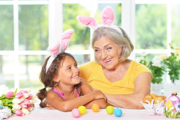 Nonna anziana e la sua bella nipote con le uova di Pasqua a casa