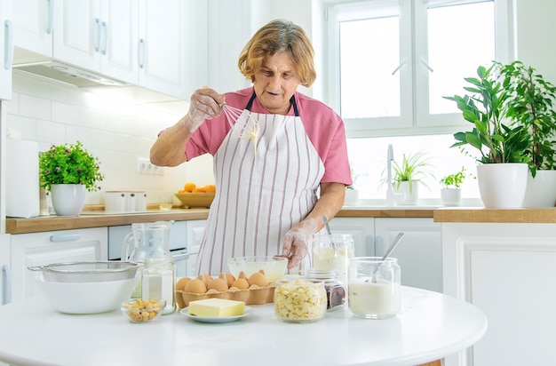 Nonna anziana in cucina cuoce prepara l'impasto in cucina Messa a fuoco selettiva Cibo