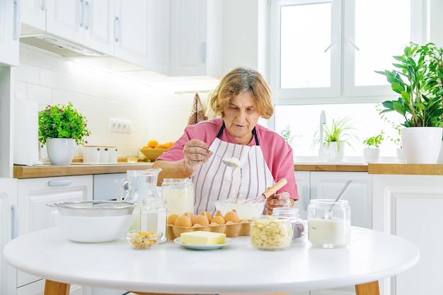 Nonna anziana in cucina cuoce prepara l'impasto in cucina Messa a fuoco selettiva Cibo