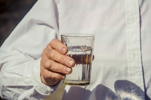 Nonna che dà un bicchiere di acqua pulita a un bambino Messa a fuoco selettiva