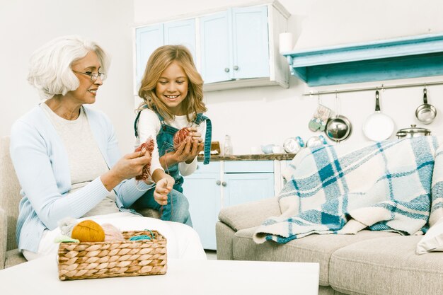 Nonna che gioca con sua nipote mentre lavorano a maglia.