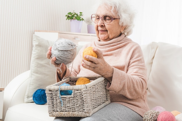 Nonna che sceglie palline di lacci colorati dal cestino