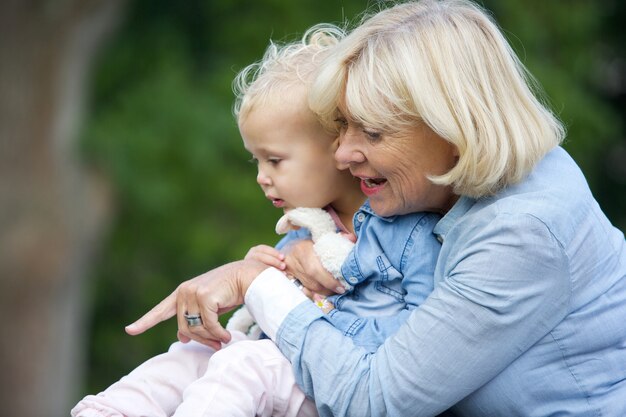 Nonna che tiene la neonata e che indica