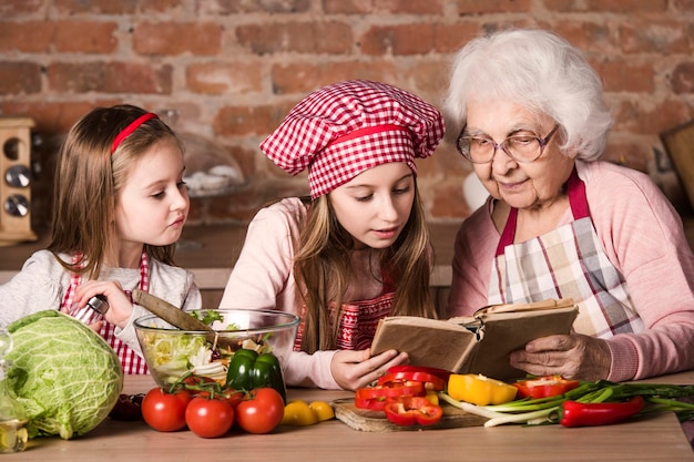 Nonna con due nipoti che leggono la ricetta