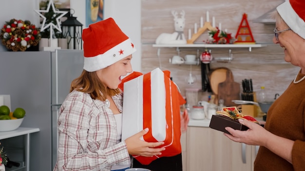 Nonna con il nonno che condivide il regalo di Natale con un nastro sopra