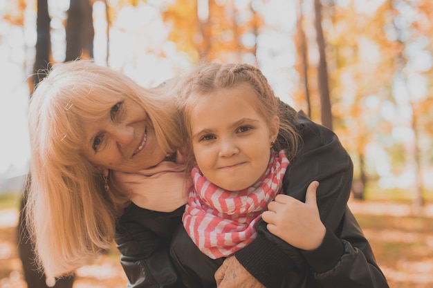 Nonna con la nipote nella generazione del parco autunnale e nel concetto di famiglia