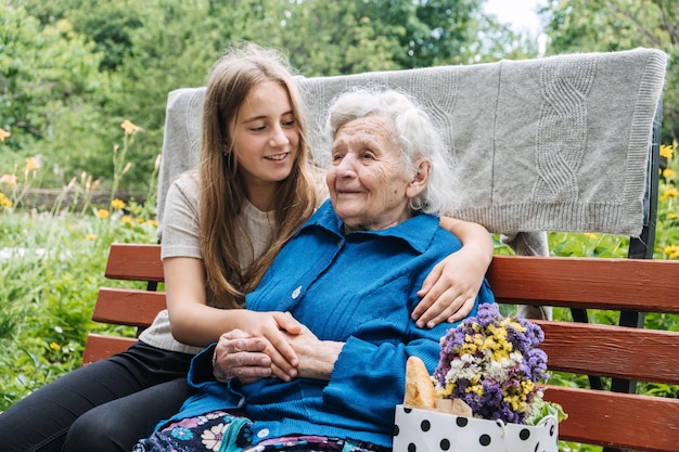 Nonna con la nipote sullo sfondo della natura Ragazza adolescente che abbraccia la nonna all'aperto felice