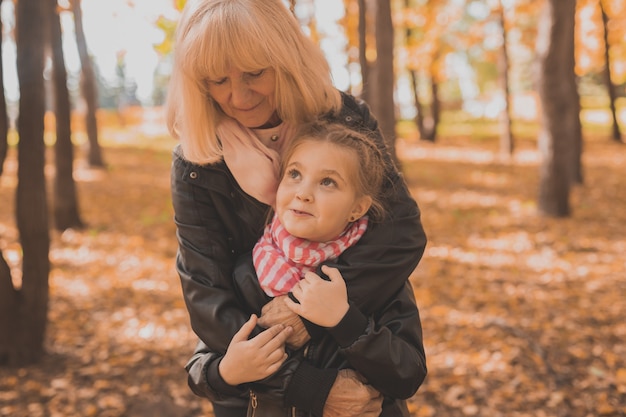 Nonna con nipote nel parco autunnale. Generazione e concetto di famiglia.
