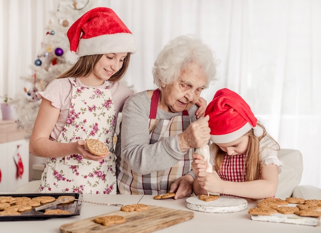 Nonna con nipoti che cuociono i biscotti