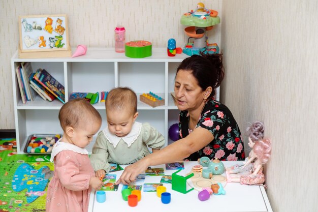 Nonna e bambini che giocano con il puzzle corrispondente