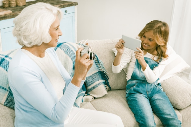 Nonna e nipote che fanno le foto usando tecnologie differenti