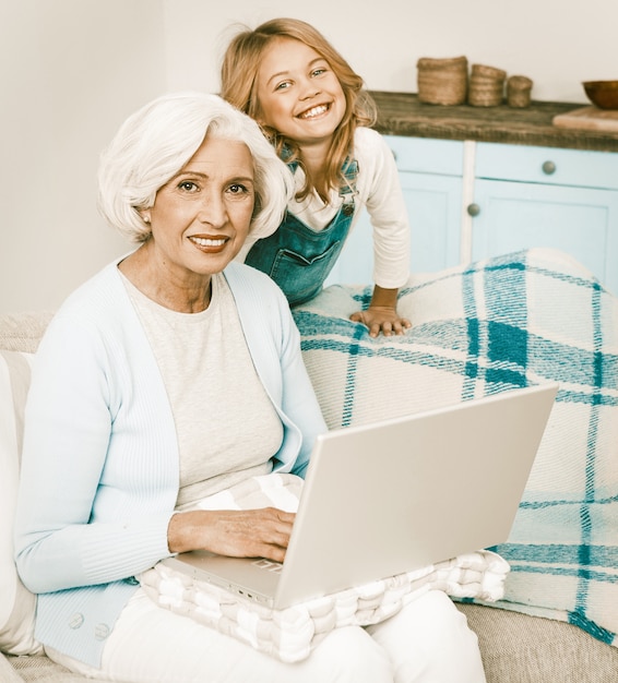 Nonna e nipote che per mezzo del computer portatile a casa