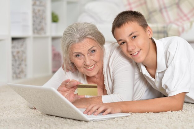 Nonna e nipote che utilizzano il concetto di acquisto online del laptop