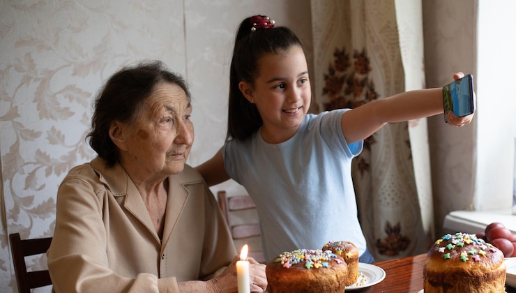Foto nonna e nipote molto anziane colorano le uova, preparando la torta pasquale per pasqua a casa.
