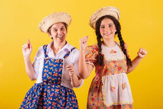 Nonna e nipote vestite con gli abiti tipici della Festa Junina Ballare festeggiando e festeggiando