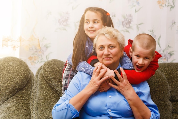 Nonna e nipoti che si siedono insieme sul divano nel soggiorno