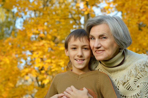 Nonna felice con il ragazzo che riposa nel parco autunnale