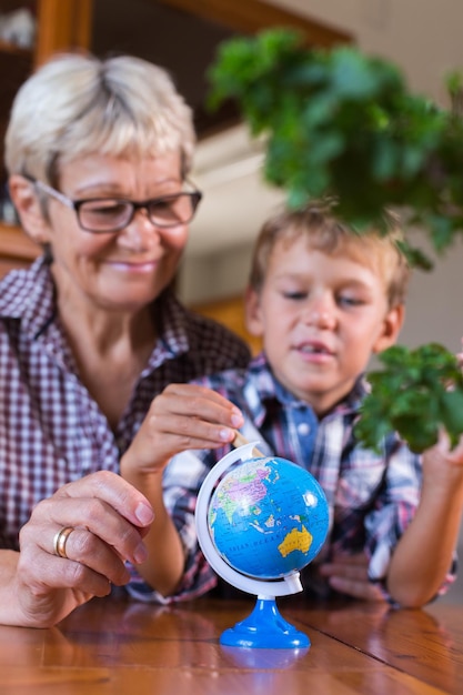 Nonna homeschooling che insegna al bambino intelligente in geografia