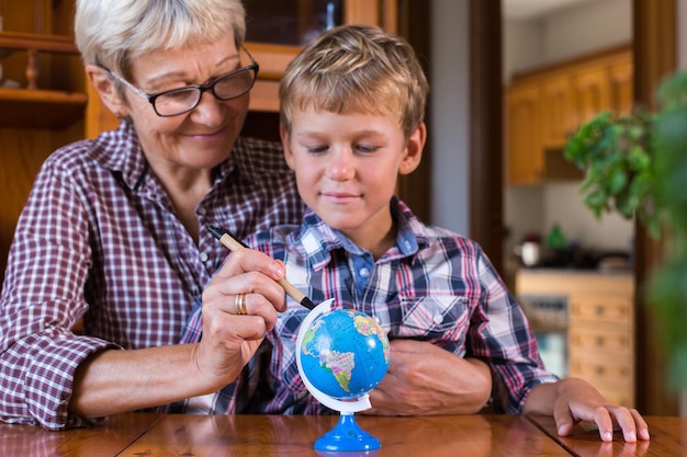 Nonna homeschooling che insegna al bambino intelligente in geografia