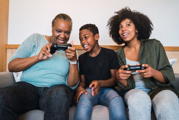 Nonna, madre e figlio che giocano a videogiochi a casa.