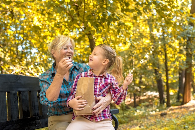 Nonna sorridente che abbraccia la sua nipotina nel parco