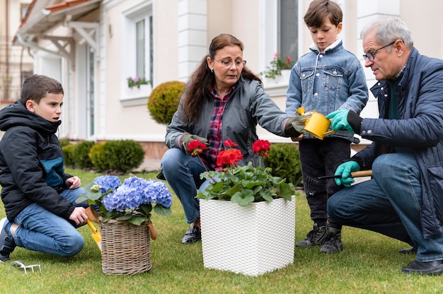 Nonni che lavorano in giardino con i nipoti