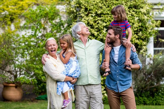 Nonni con nipoti e figlio in piedi in cortile